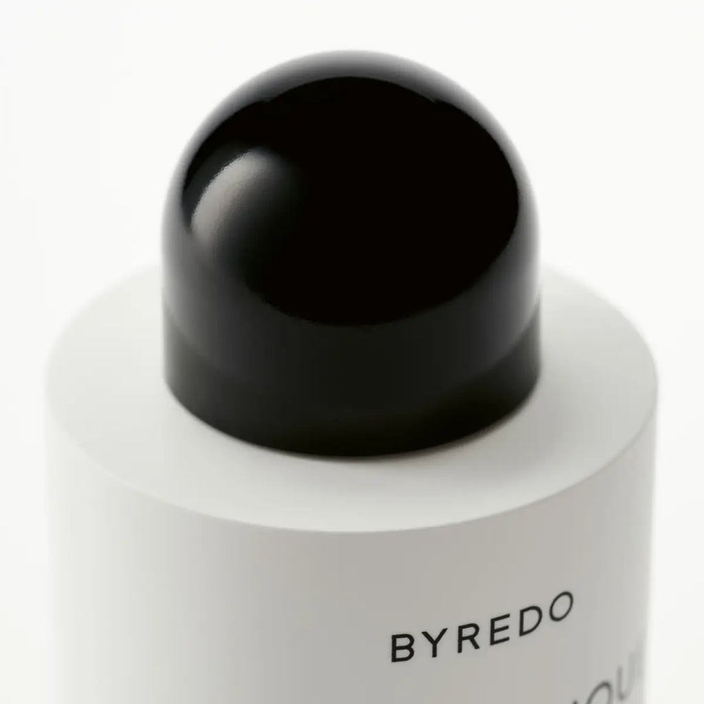 Close-up of a Byredo rose of no man's land body lotion with a black cap on a white background