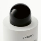 Close-up of a Byredo blanche body lotion bottle with a black cap on a white background