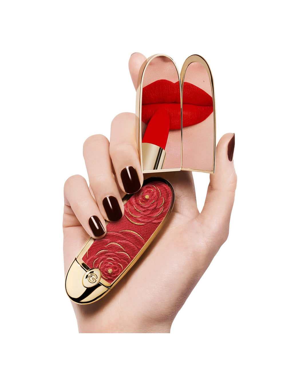Guerlain Rouge G red lipstick with gold case held in hand against a white background