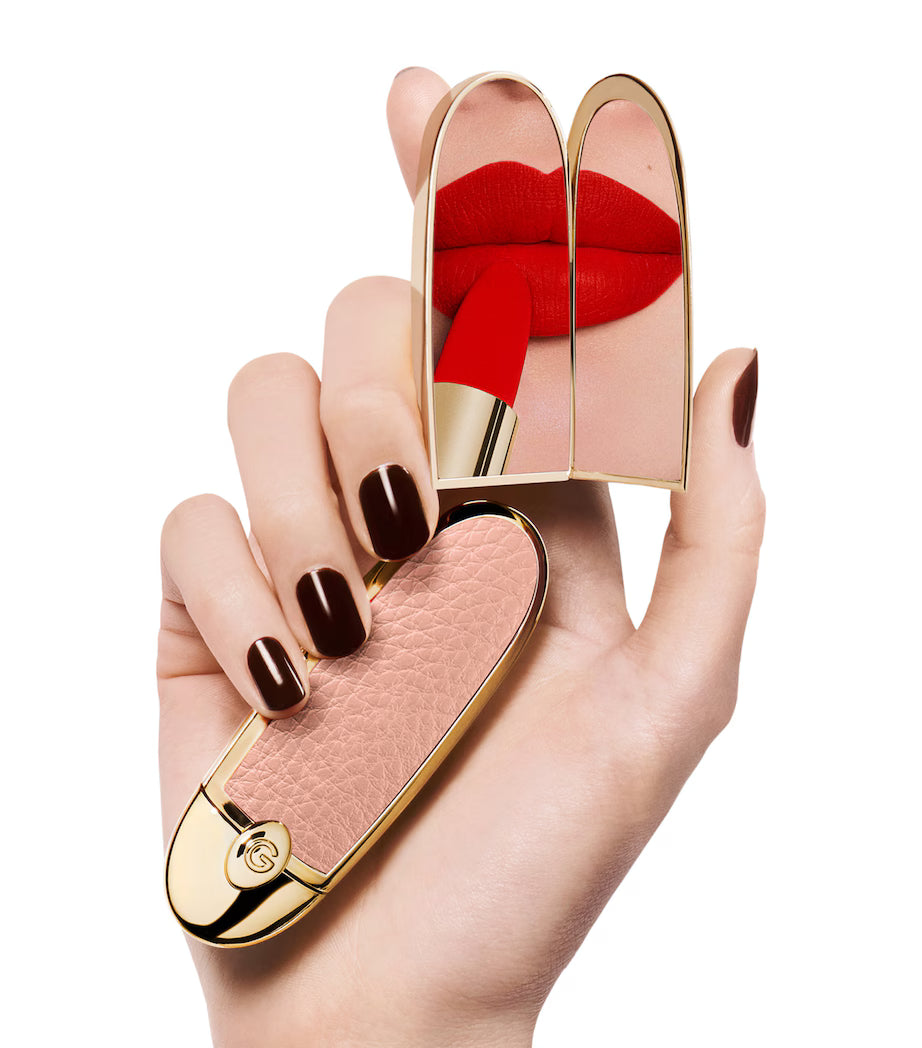 Hand holding Guerlain Rouge G The Double Mirror Case Le Nude with red lipstick reflected in the double mirror