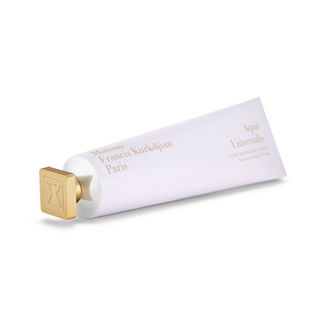 Maison Francis Kurkdjian Aqua Universalis scented hand cream in a white tube with gold cap, angled view on a transparent background