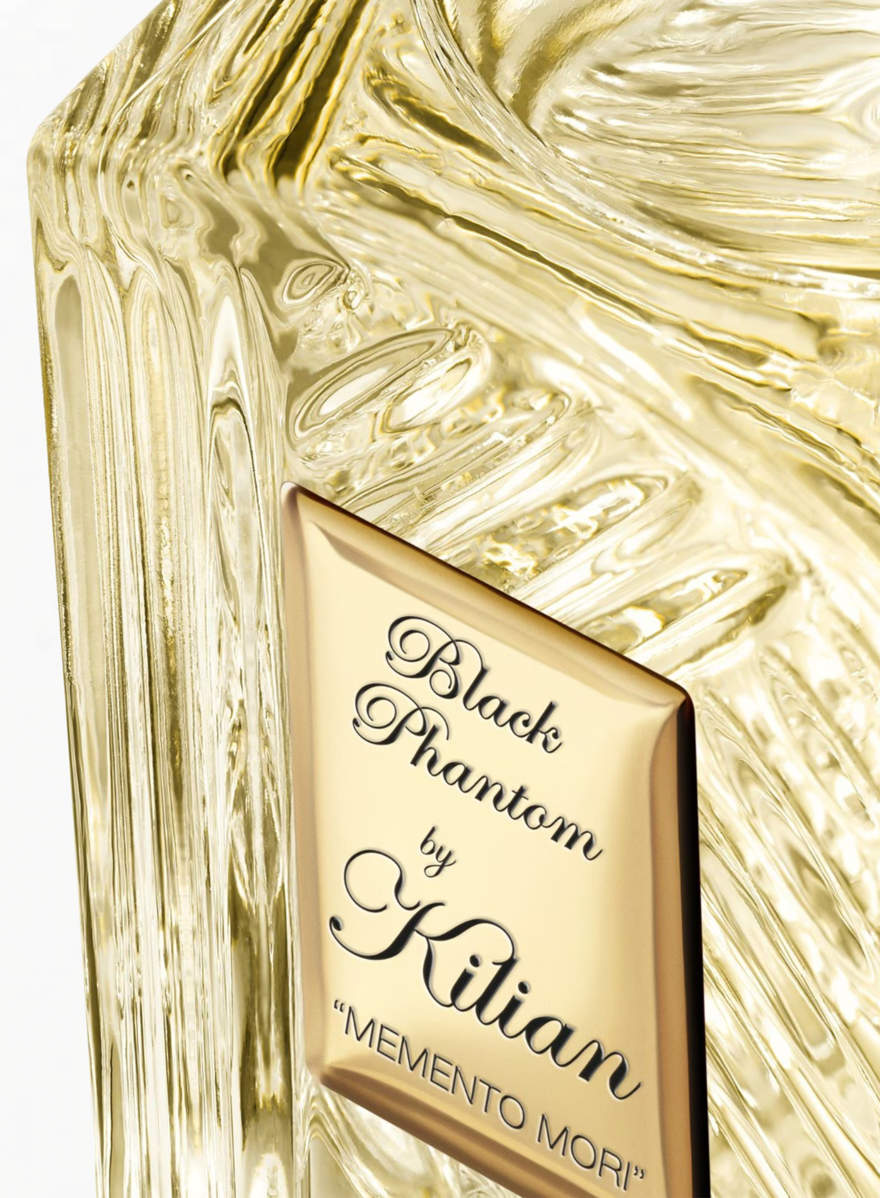 Close-up of the KILIAN Black Phantom Memento Mori Eau de Parfum bottle showcasing the signature gold plaque and sculpted glass details