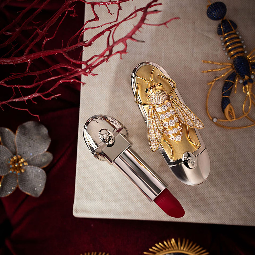 Luxury lipstick with decorative cap on a textured surface