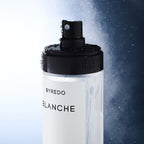 Byredo Blanche body mist bottle with a black spray cap on a gradient background