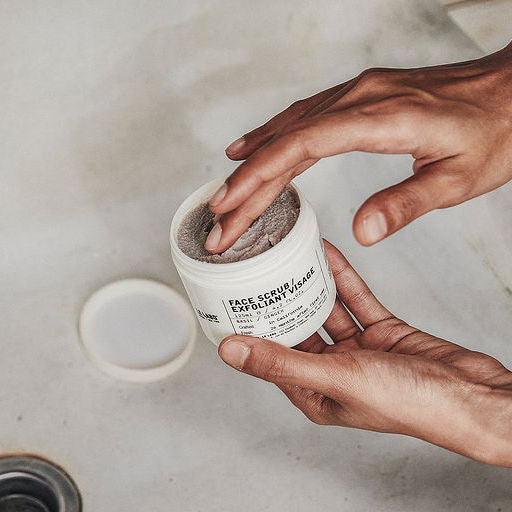 le labo Person using a face scrub exfoliating wash with a marble background