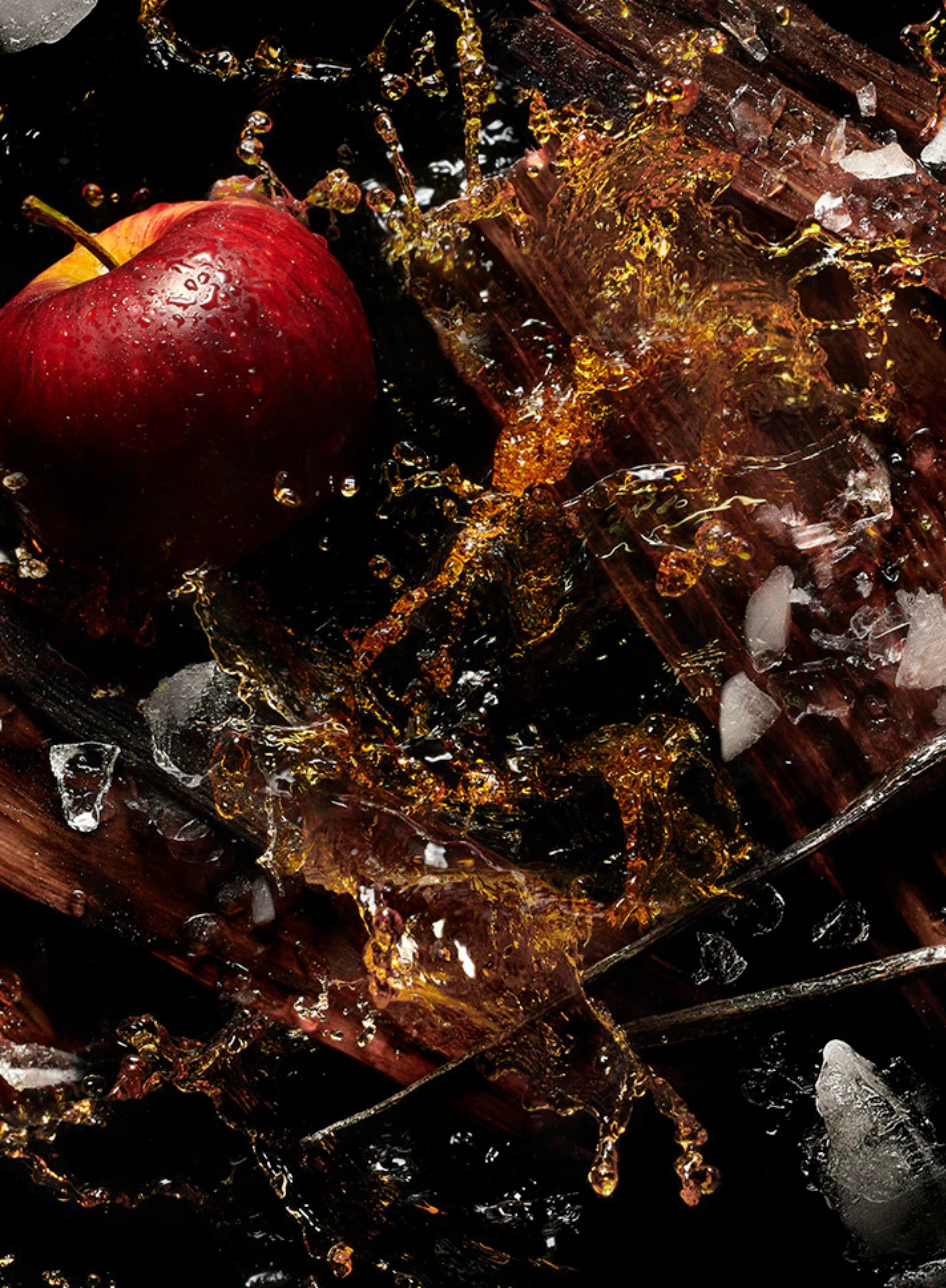 Red apple, apple brandy splash, ice, and oak wood capturing the fresh, boozy inspiration behind KILIAN Apple Brandy on the Rocks Eau de Parfum