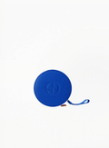 Blue round Giorgio Armani cosmetic pouch with embossed logo and wrist strap on a white background.
