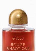 Byredo Rouge Chaotique perfume bottle with gold cap on a white background