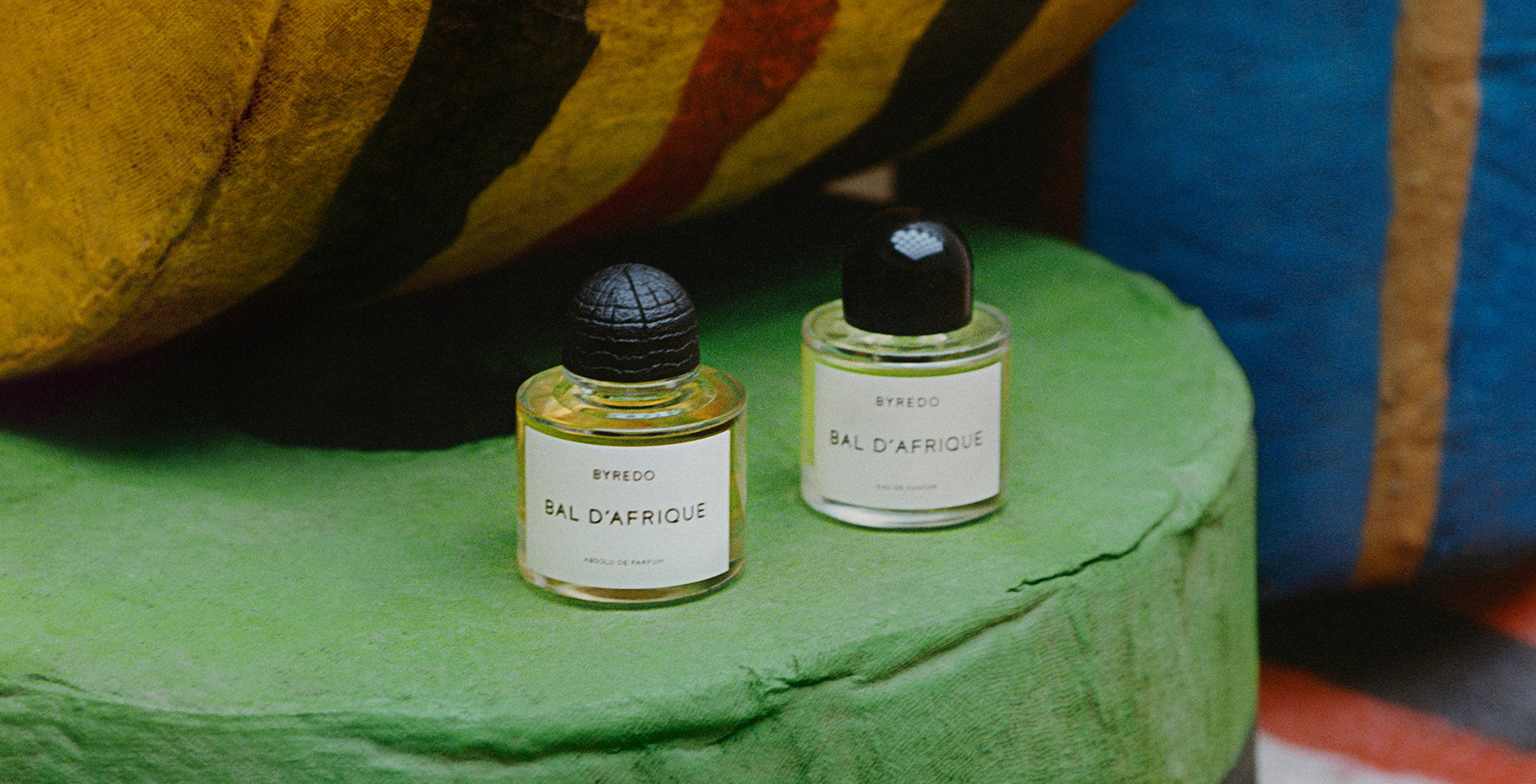 BYREDO Bal d’Afrique perfume bottles on green surface – authentic luxury fragrance at Exquisite