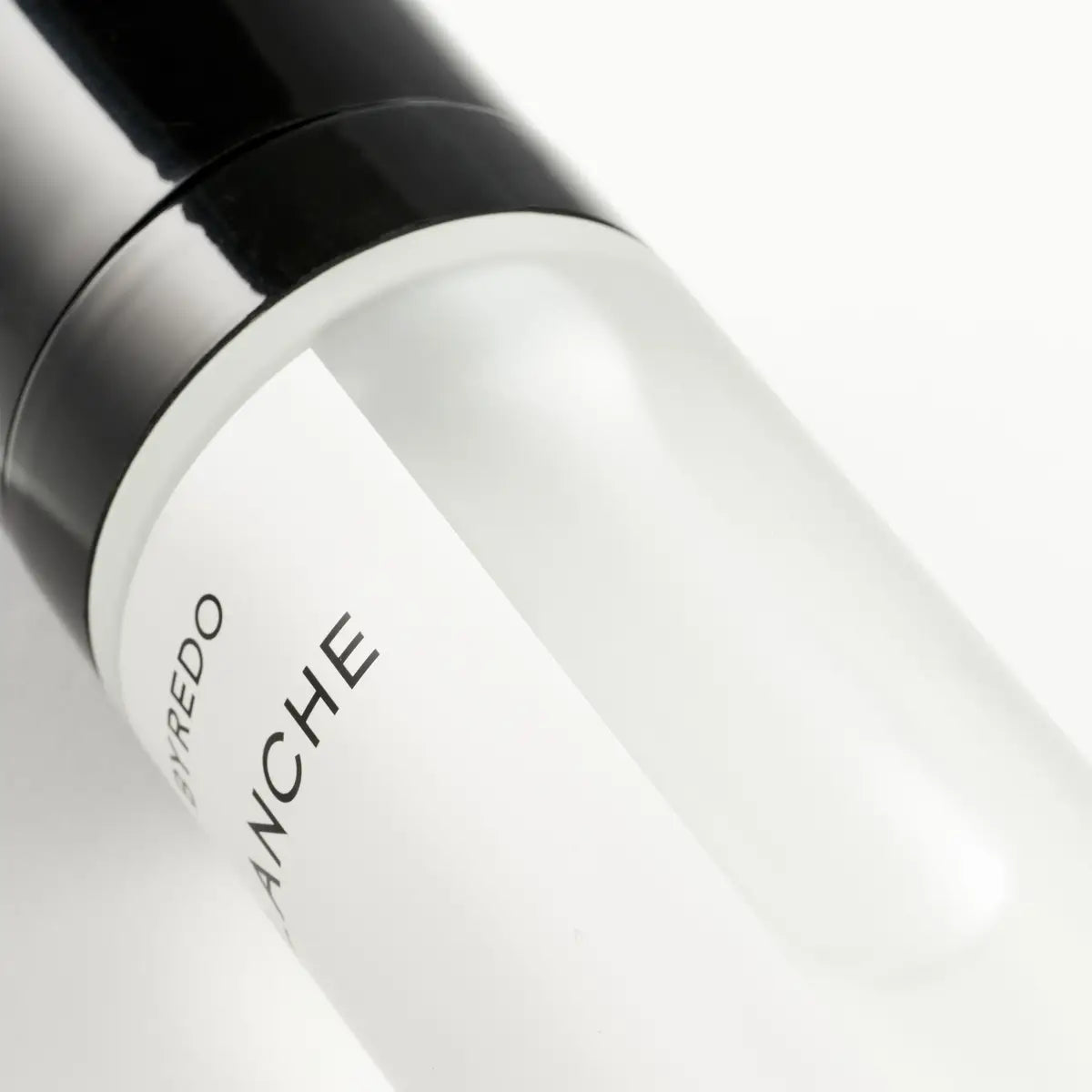 Close-up detail of a BYREDO Body Mist bottle featuring the minimalist label and glossy black cap on a clean light background.