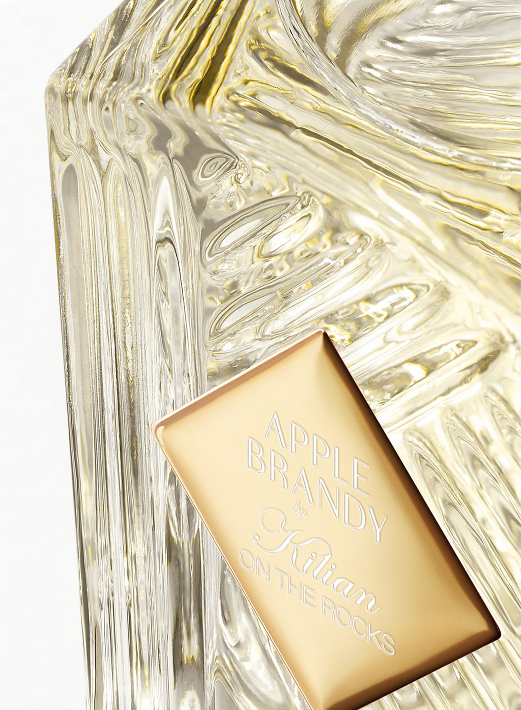 Close-up of the KILIAN Apple Brandy on the Rocks Eau de Parfum bottle showcasing the signature gold plaque and sculpted glass details