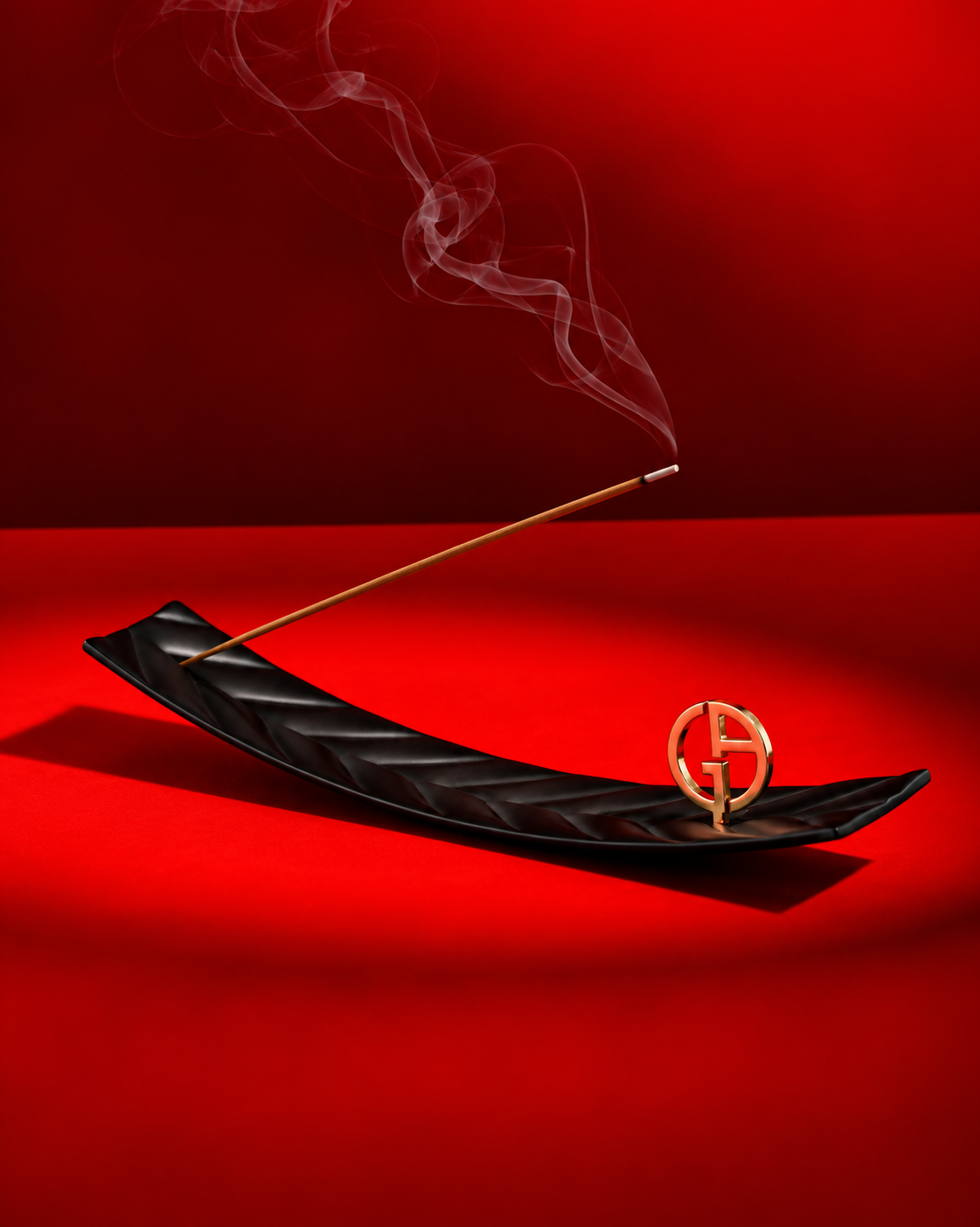 Giorgio Armani incense holder with burning incense stick and delicate smoke against a deep red background.