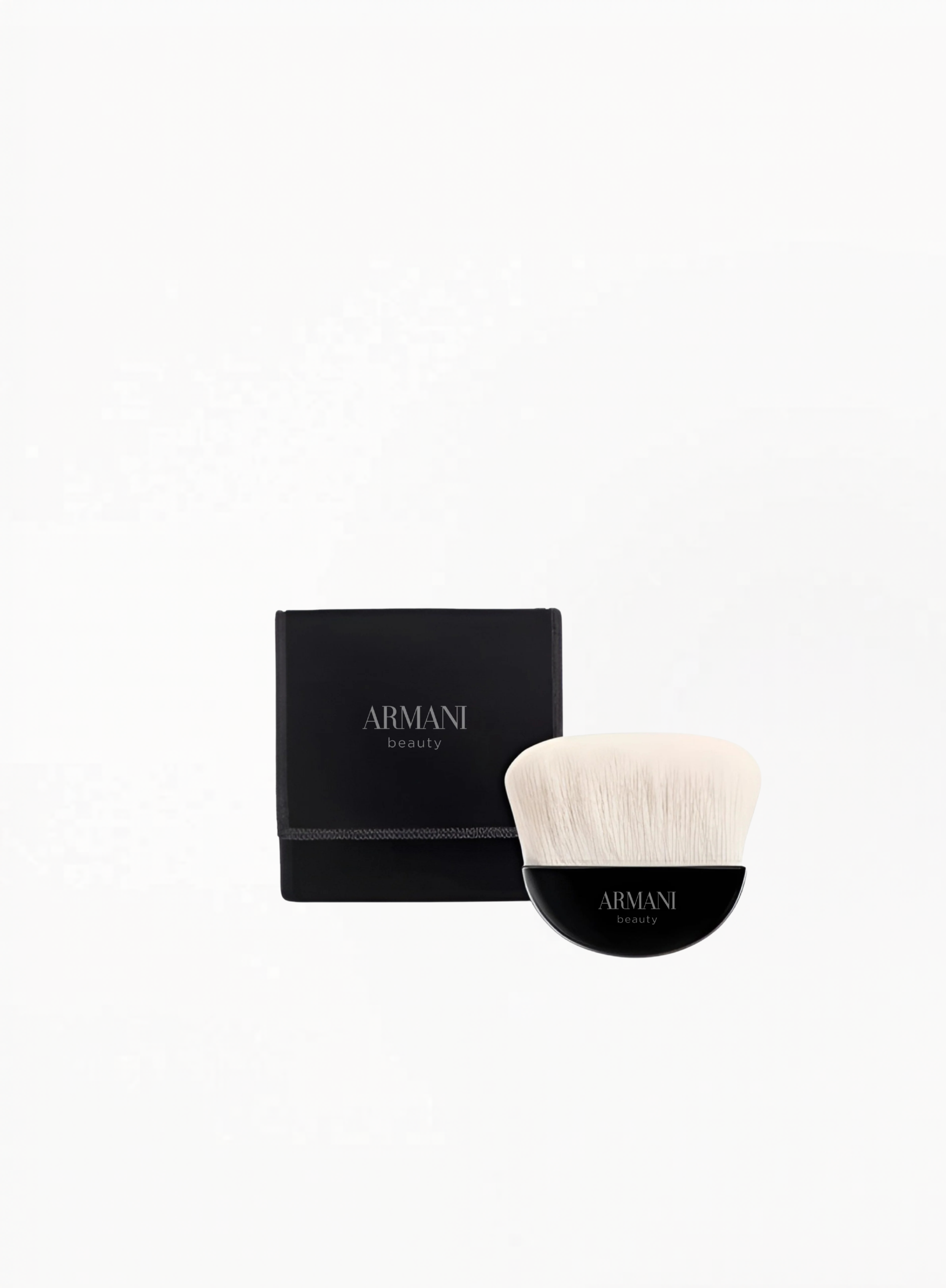 Giorgio Armani mini makeup brush with soft white bristles and black Armani Beauty case, displayed on a clean white background.
