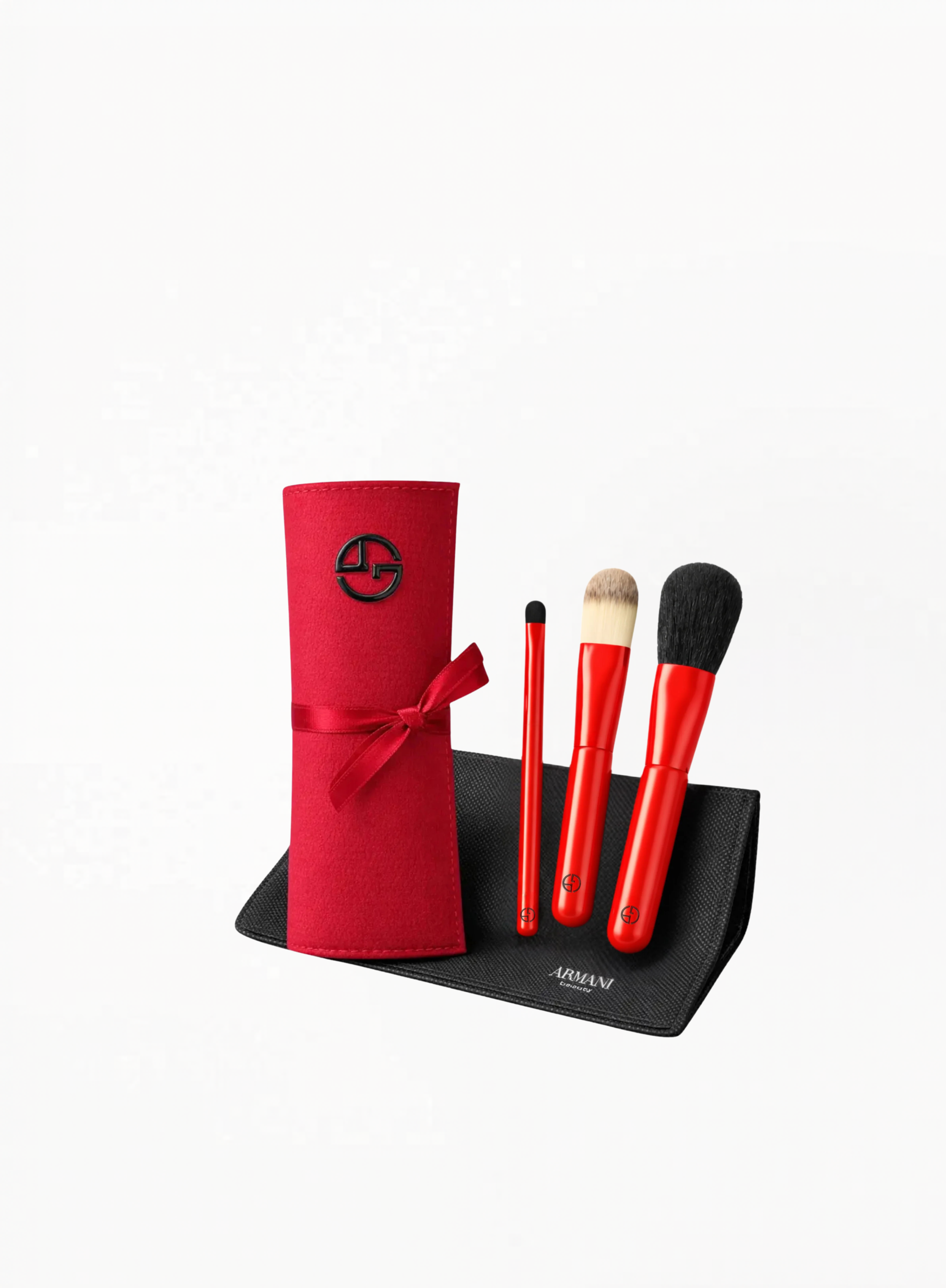 Giorgio Armani red limited edition makeup brush set with three brushes, red roll-up case, and black pouch on a white background, available at Exquisite.