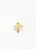 Guerlain gold bee charm, brooch with openwork wing details, displayed on a clean elegant background featuring refined luxury accessory craftsmanship and minimalist decorative design.