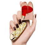 Guerlain Rouge G Stellar gold geometric double mirror lipstick case held in hand with red lipstick reflection