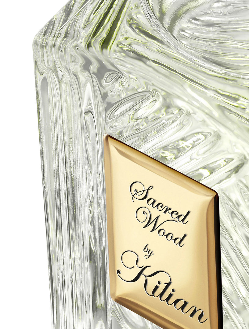 Kilian Paris Sacred Wood Eau de Parfum close-up of gold engraved label on faceted crystal bottle

