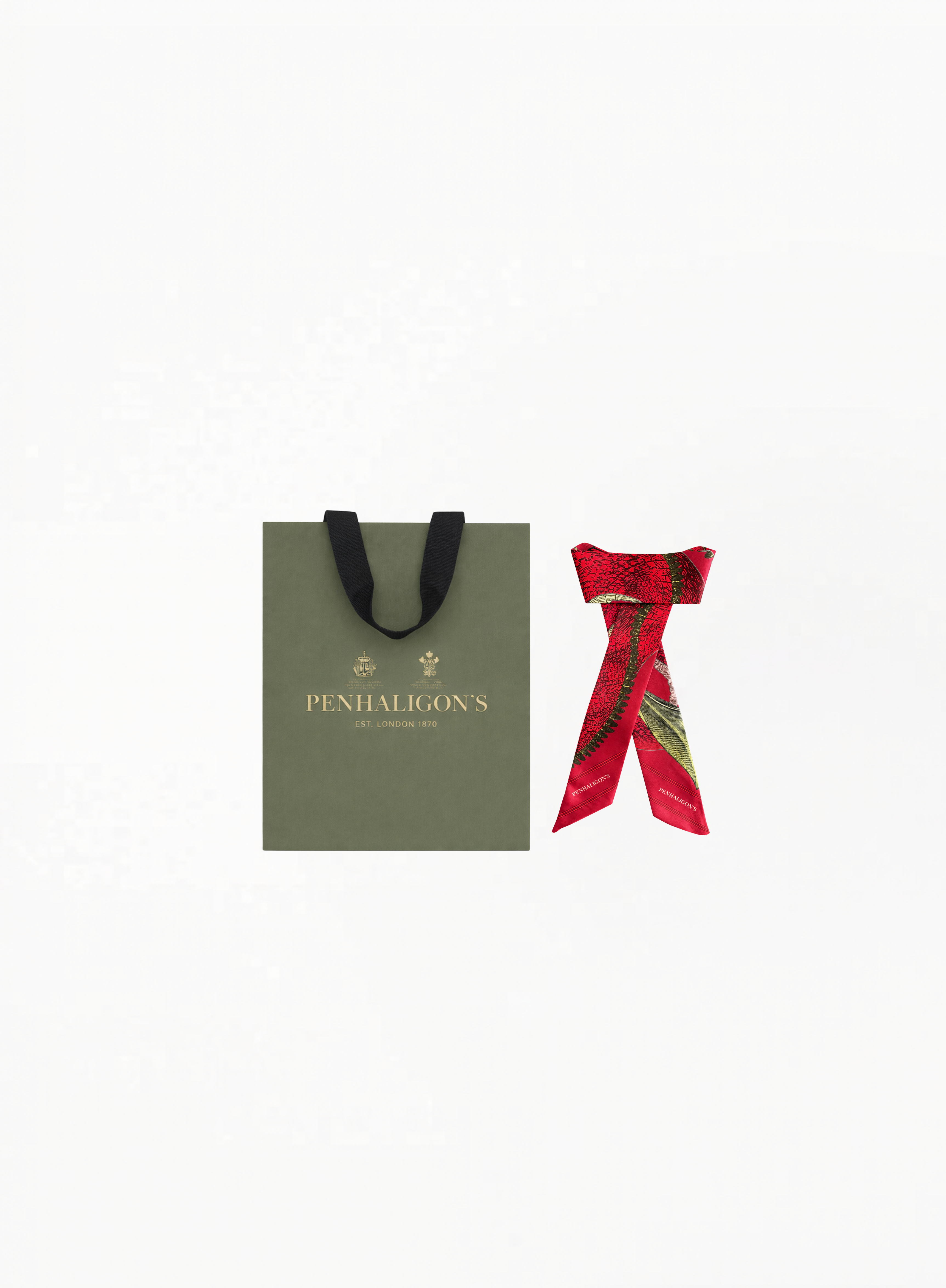 Penhaligon’s limited edition red silk twilly scarf with botanical-inspired illustration and elegant branded detailing on a clean background for Exquisite.