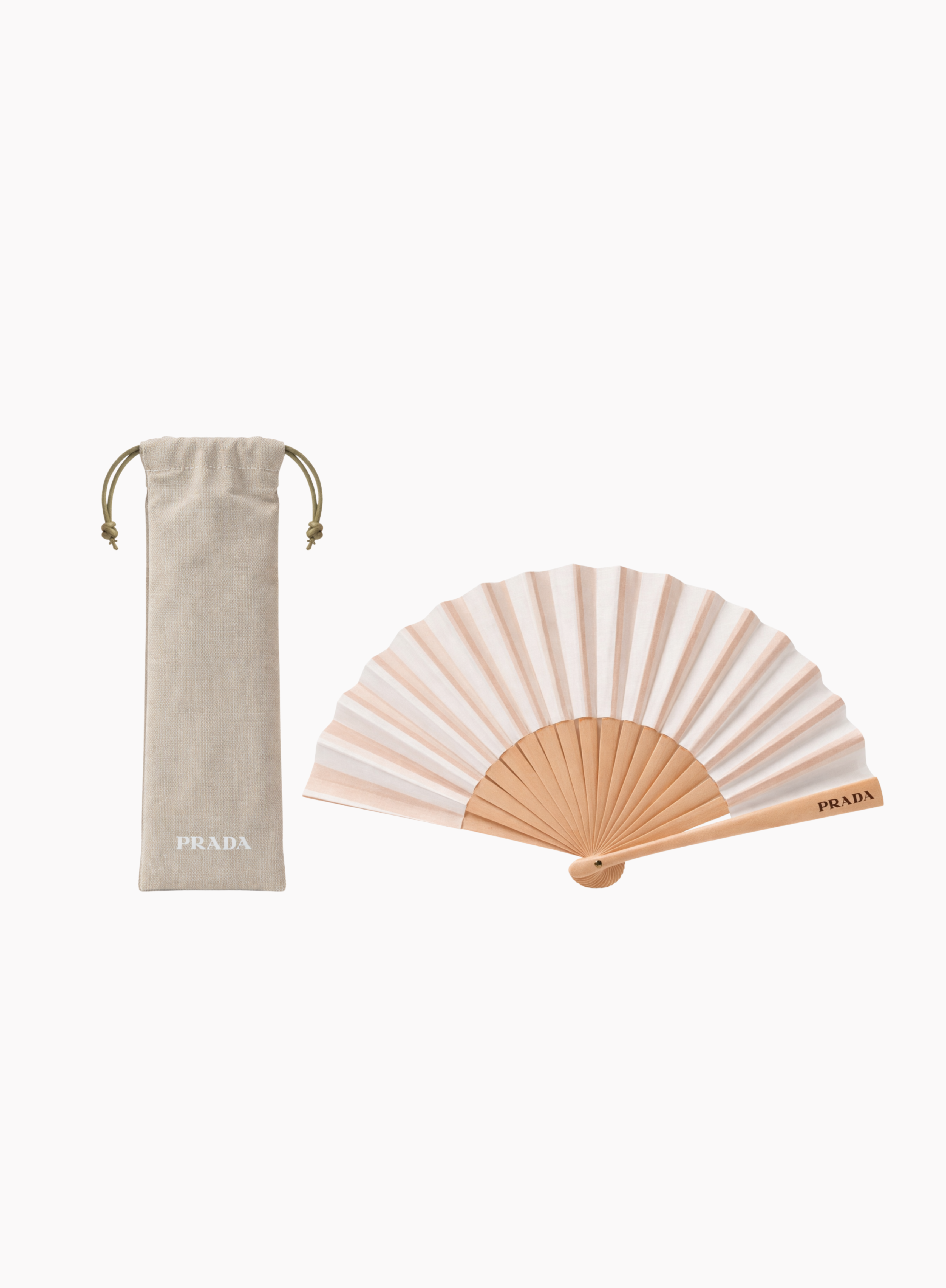 PRADA folding hand fan in soft beige and blush striped fabric with a natural wood frame, displayed alongside a matching beige drawstring pouch with PRADA logo on a clean light background. Available at Exquisite.