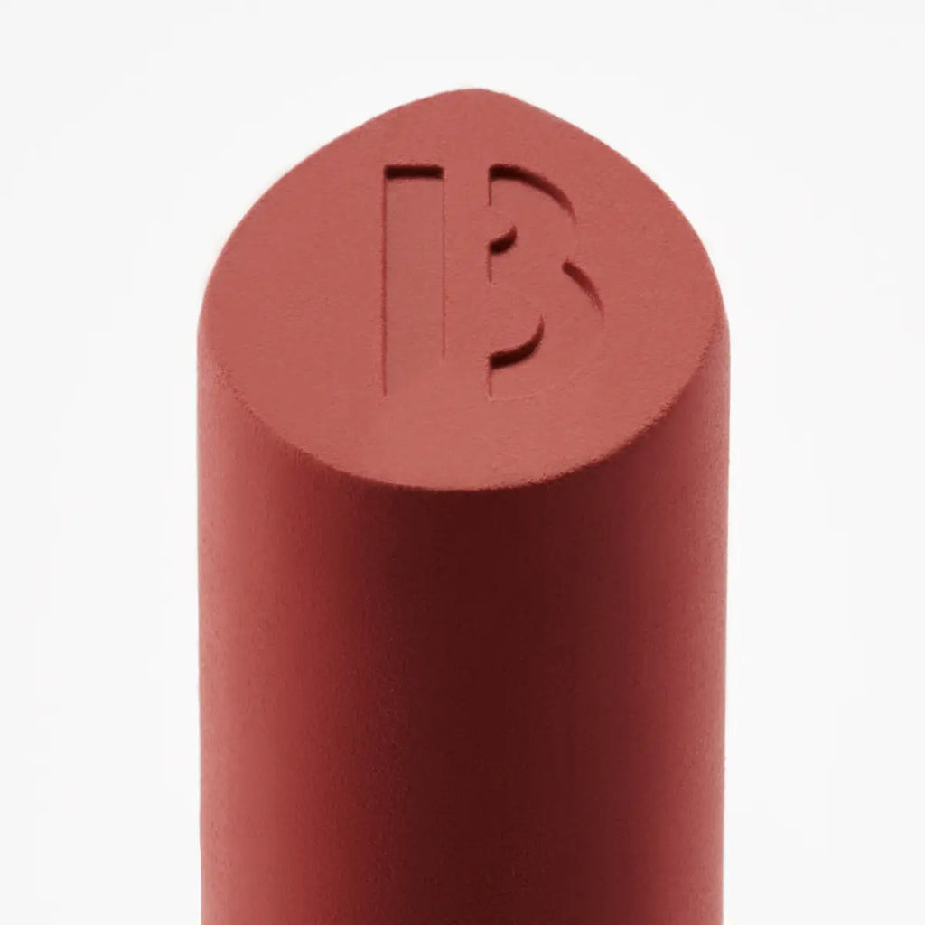 Byredo lipstick bullet close-up with engraved logo warm red
