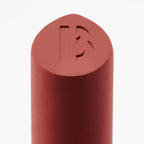 Byredo lipstick bullet close-up with engraved logo warm red
