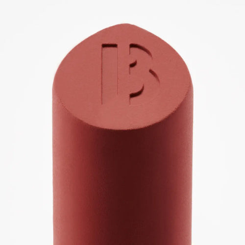 Byredo lipstick bullet close-up with engraved logo warm red
