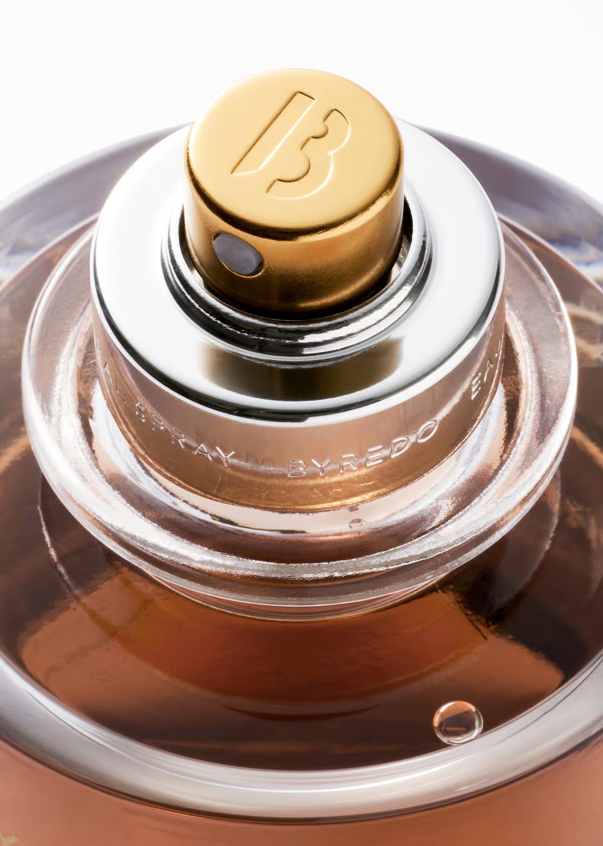 BYREDO Bois Obscur Extrait de Parfum 70ML Close-up of a perfume bottle with a gold cap and clear glass body.