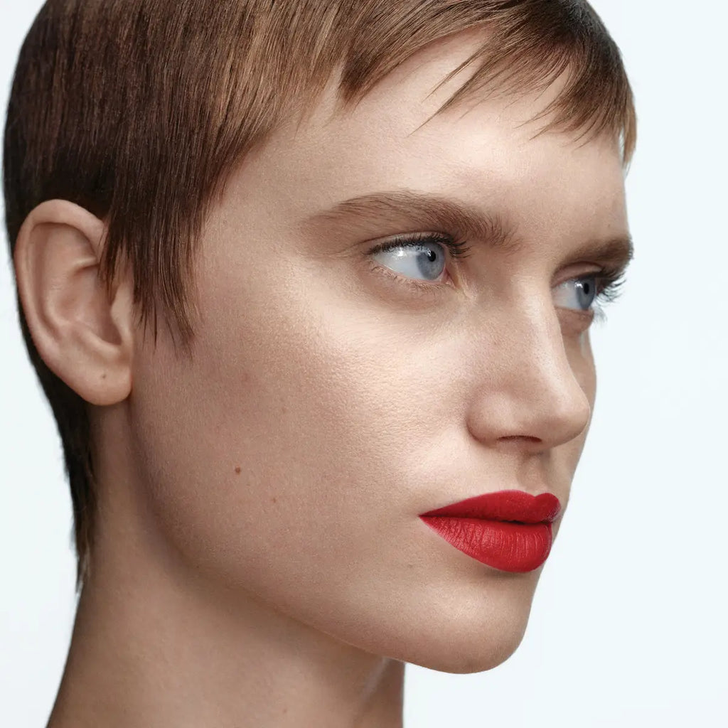 Model wearing Byredo Matte Lipstick Eperdu 224 soft red shade close-up
