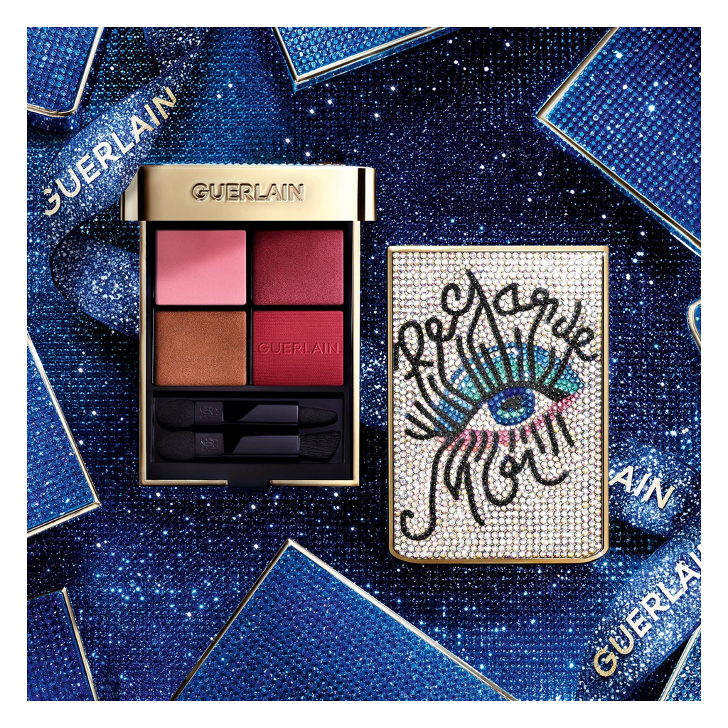 GUERLAIN Ombres G limited edition eyeshadow palette with jeweled eye motif case, featuring four pigmented shades and applicators, styled on a blue sparkling background — authentic luxury eyeshadow palette available at Exquisite Georgia.