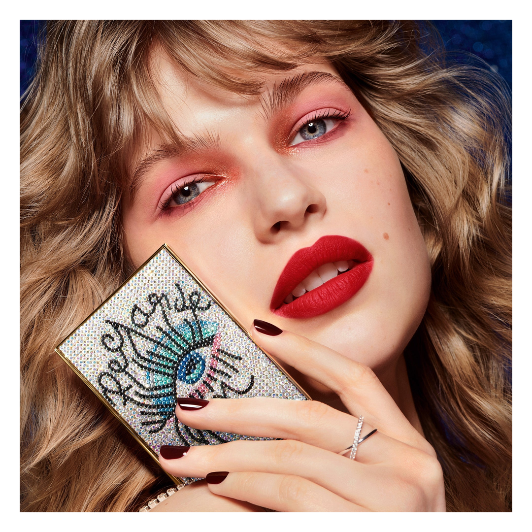Model showcasing GUERLAIN Ombres G limited edition palette with jeweled eye motif case, featuring vibrant eye makeup and bold red lipstick — authentic luxury beauty collection available at Exquisite Georgia.